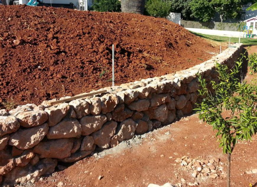 Bau einer Gartenmauer um den Pool-Gügel herum